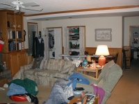 Looking towards the back of the family room, the couch, recliner, and closets can be seen.  The door on the right enters the office.