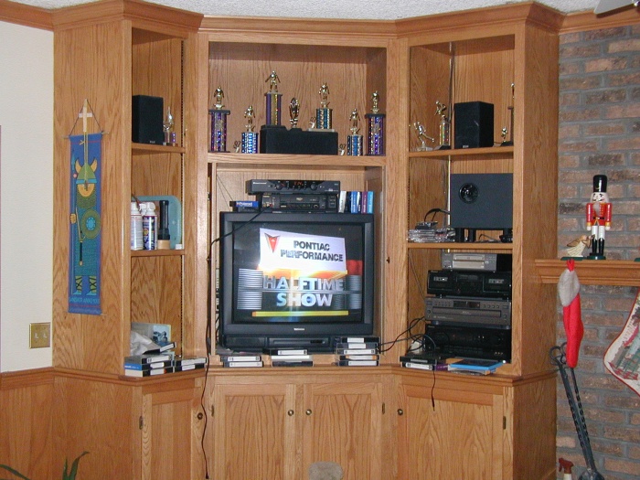 The entertainment center.  Above the TV are assorted trophies, and to the right of the TV is the sound system.