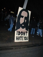 A sign painted on a 4x8 sheet of plywood, facing the godhatesfags people.